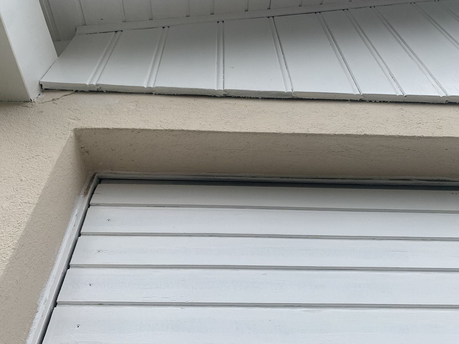 Dessous de toit, planche de rive et bardage en bois repeints en blanc après travaux