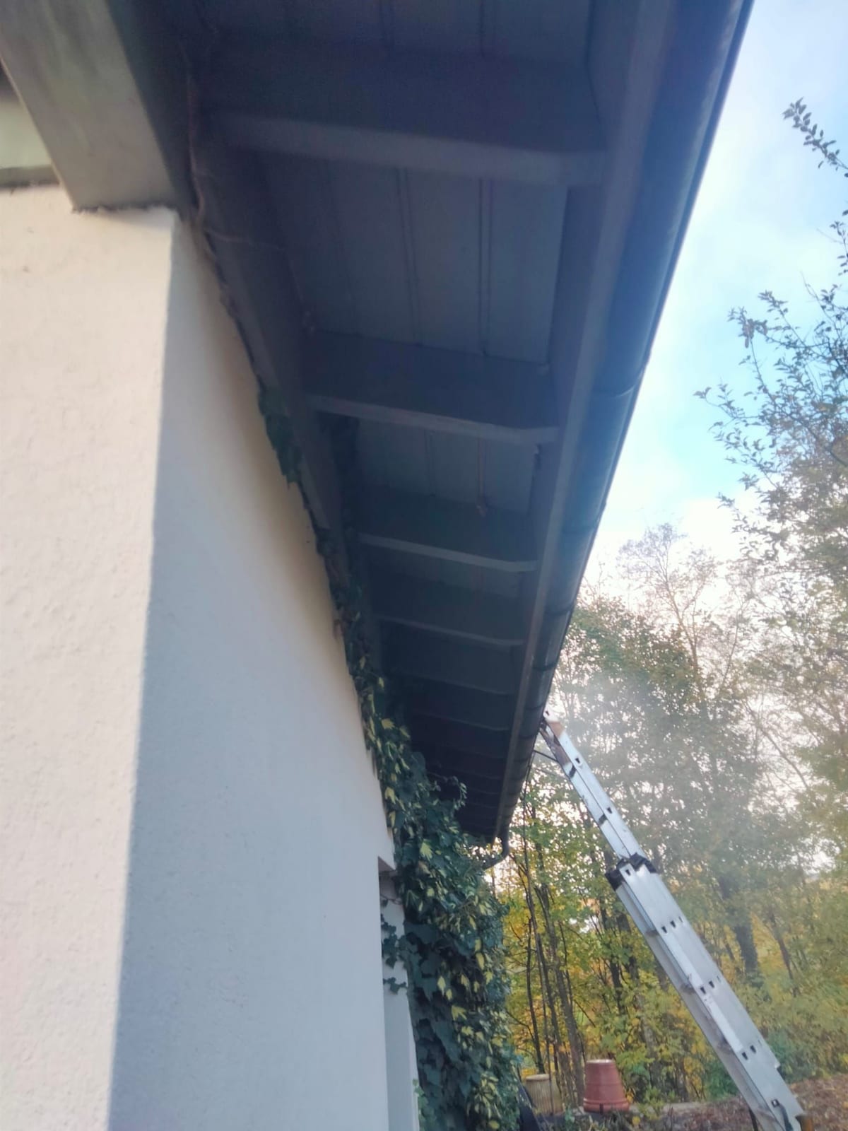 Avant-toit en bois dégradé et gouttière métallique d’une villa
